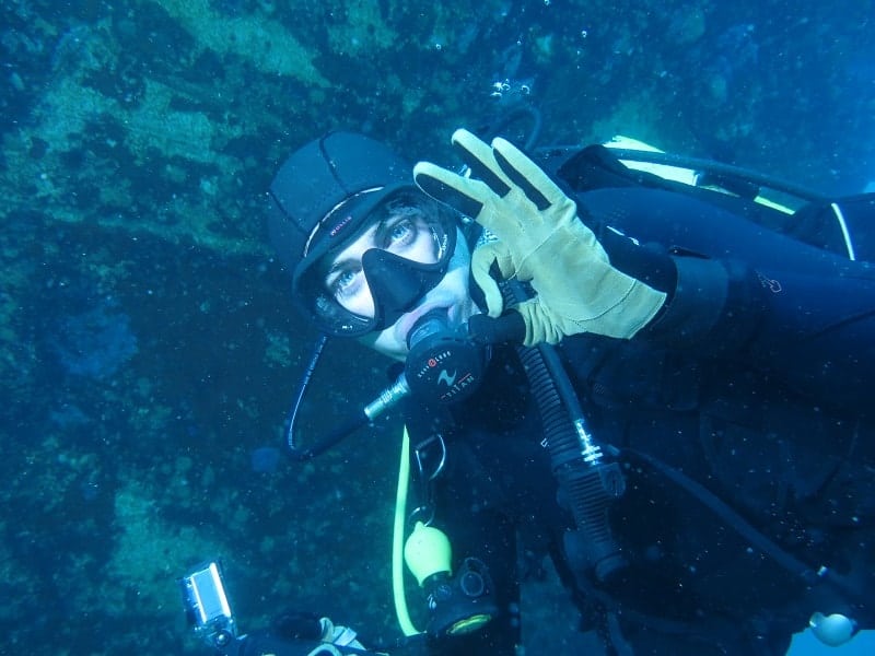 a person swimming underwater give ok signal
