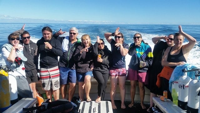 a group of people posing for a photo in front of water