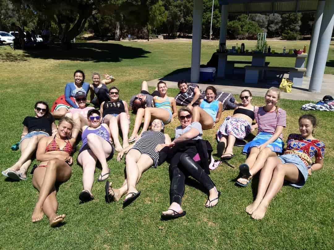 a group of people playing frisbee in a grassy field