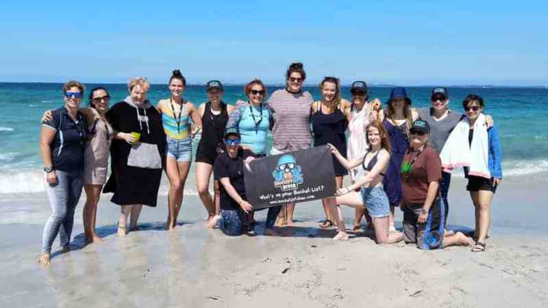 a group of people standing on top of a sandy beach