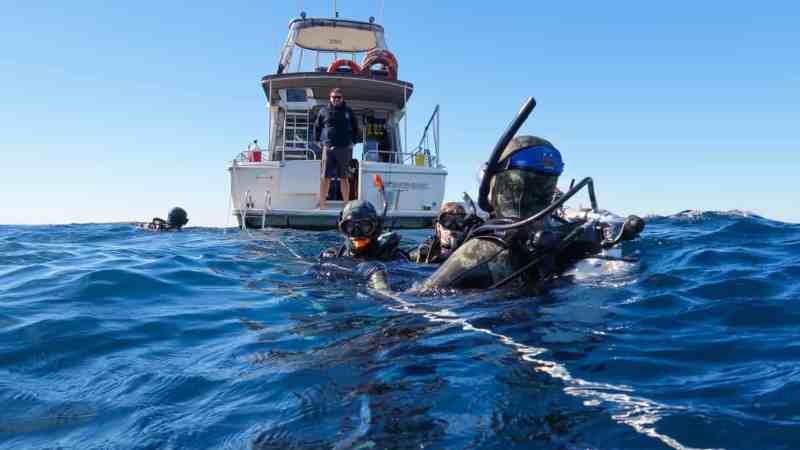 a man riding on the back of a boat in the water