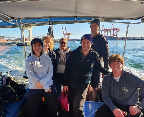 a group of people on a boat posing for the camera