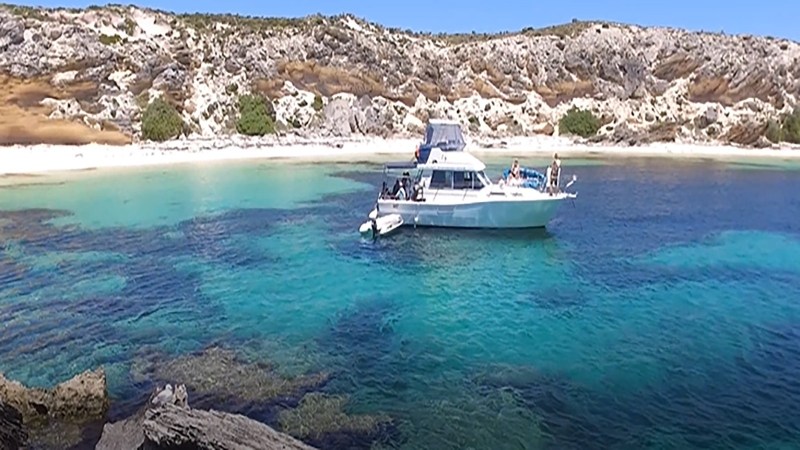 a blue and white boat sitting next to a body of water
