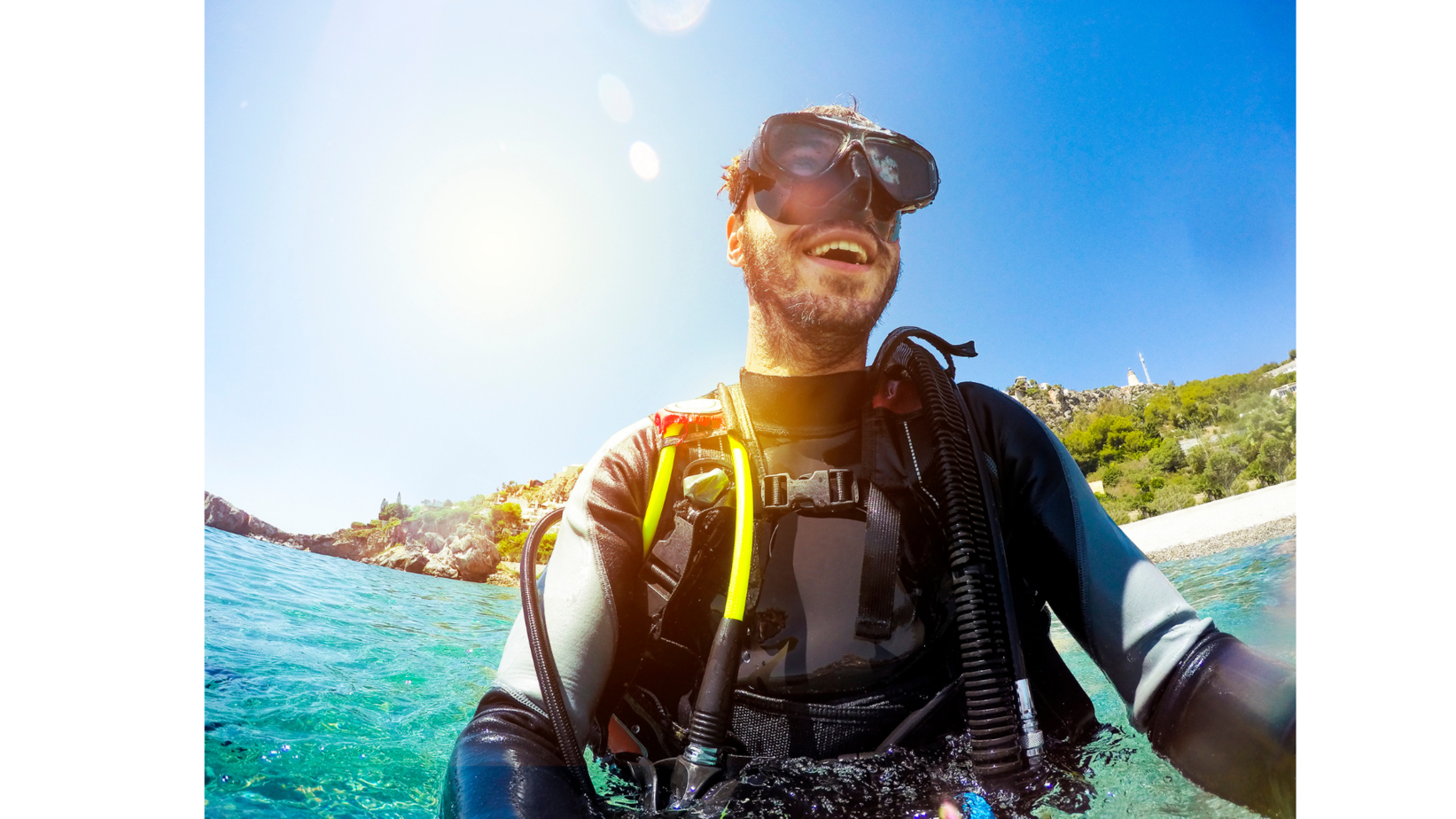 Male Diver smiling a person standing next to a body of water