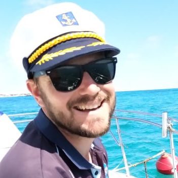 240962146_379407546977878_335091832839737290_n a person wearing a hat and sunglasses posing near a body of water