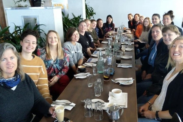 a group of people sitting at a table posing for the camera
