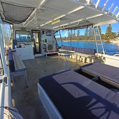 Interior of a boat with benches, open sides, and water view.