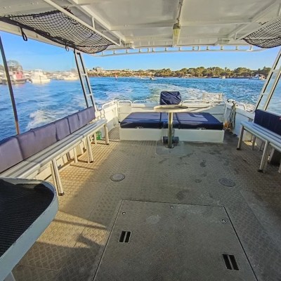 Boat interior view with benches, table, and ocean in the background.